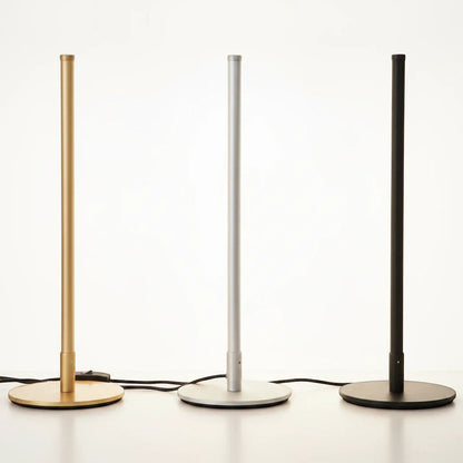Lysverden minimalist LED floor lamps in gold, silver, and black metal standing in a row on a white surface.