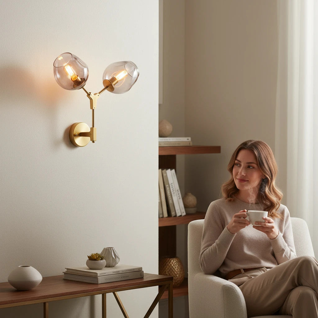 Lysverden Molekyl wall lamp with two smoke-colored glass globes on a gold brass branch in a cozy living room setting.