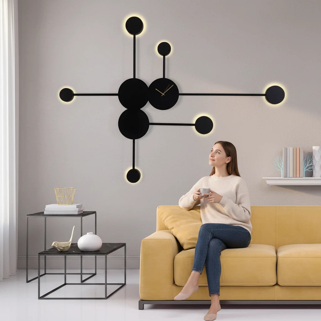 Lysverden Molekyl sputnik wall lamp with black and gold accents, mounted above a yellow sofa in a modern living room.