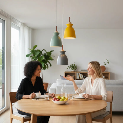 Lysverden Nordic cone pendant lights in yellow, green, and grey hanging over a wooden dining table with two women.