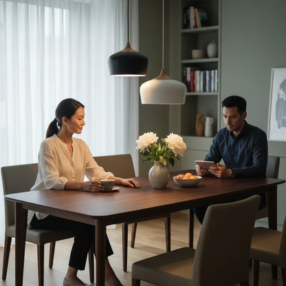 Lysverden Nordisk pendant lamps with black and white metal domes and wood accents hanging over a dining table.
