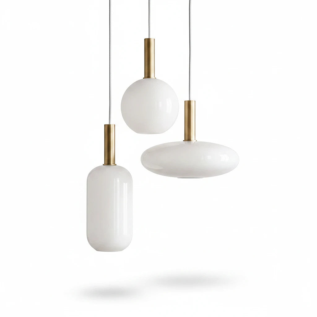 Lysverden opal glass pendant lamps with gold stems in cylindrical, spherical, and disc shapes against white background