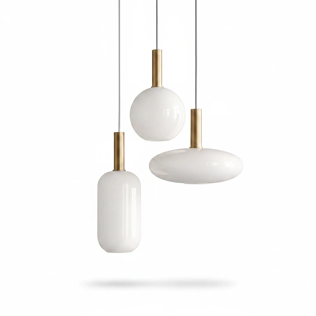 Lysverden opal glass pendant lamps with gold stems in three different shapes hanging against a white background