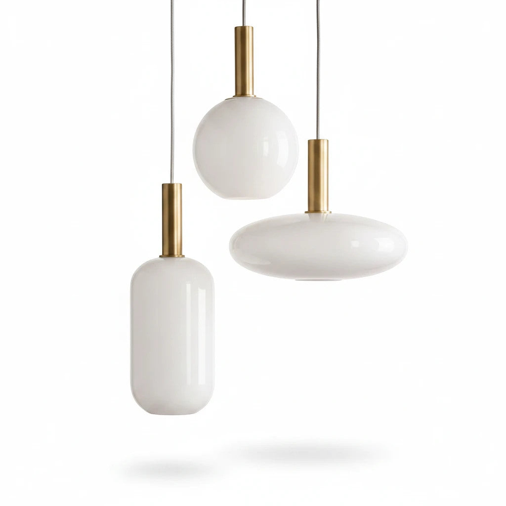 Lysverden opalglass pendant lamps with gold stems in three different shapes hanging against a white background.