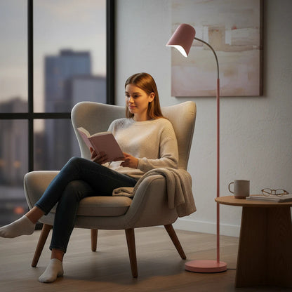 Lysverden minimalist pink metal floor lamp with adjustable cone shade providing reading light next to a cozy armchair