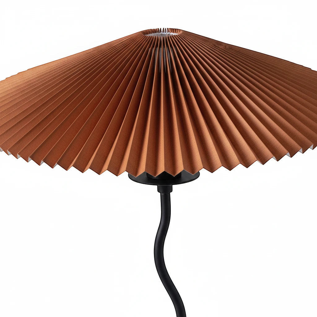 Lysverden sculptural floor lamp with a pleated rust-colored disc shade and a sleek black wavy metal stem.