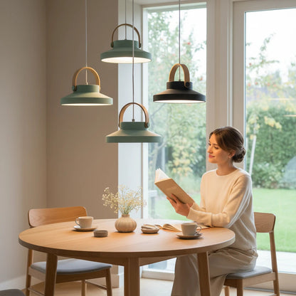 Lysverden retro pendant lamps with brass handles hanging over a wooden dining table where a woman reads a book.