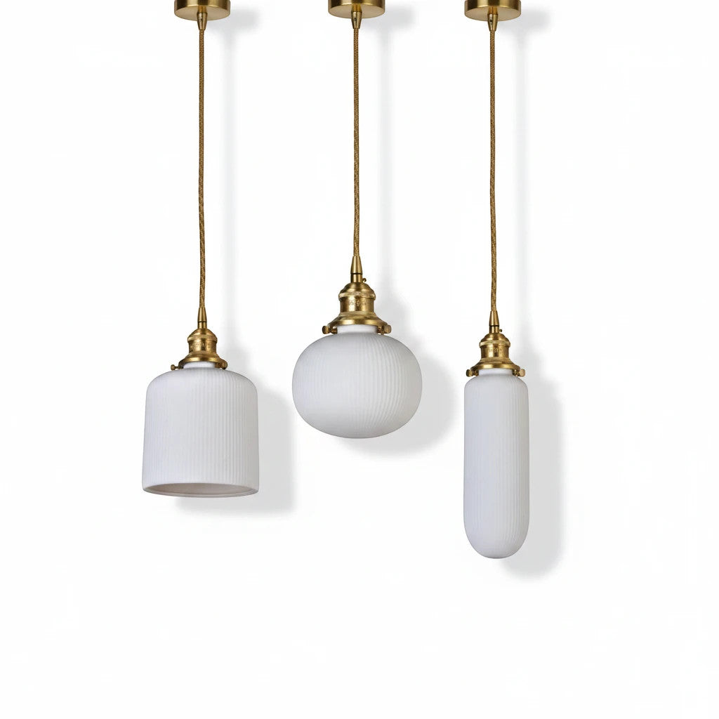 Lysverden RILLE pendant lights featuring white ribbed opal glass shades and elegant brass details in three distinct shapes.