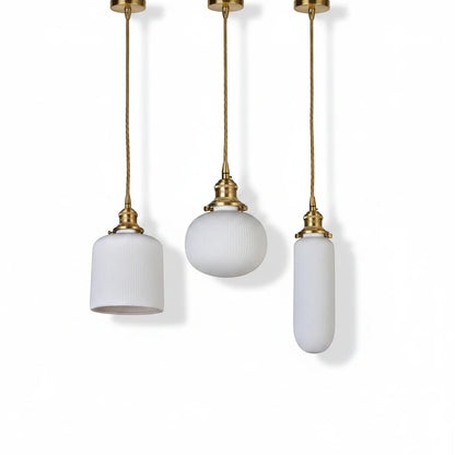 Lysverden RILLE pendant lights featuring white ribbed opal glass shades and elegant brass details in three distinct shapes.