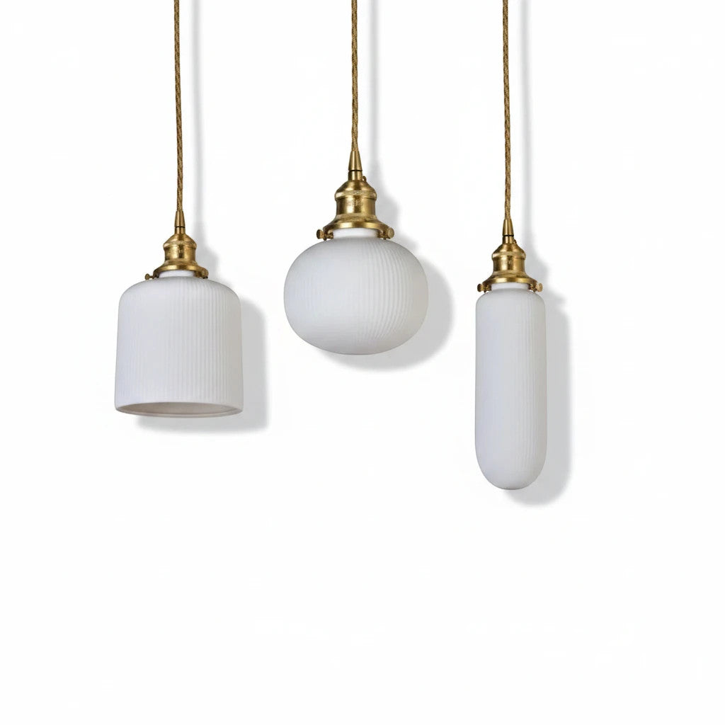 Lysverden RILLE pendant lamps in white ribbed opal glass with brass details in three different shapes.