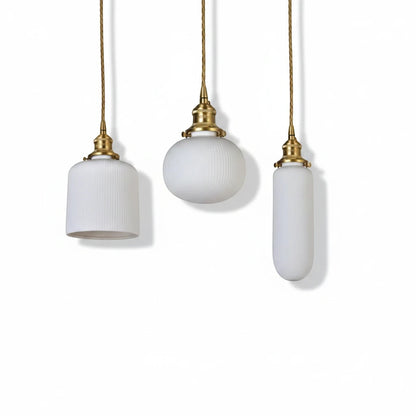 Lysverden RILLE pendant lamps in white ribbed opal glass with brass details in three different shapes.