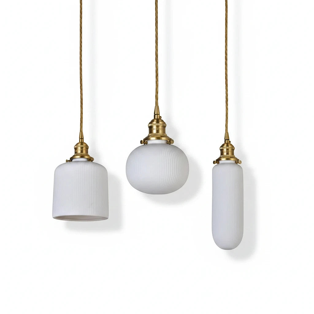 Lysverden RILLE pendant lights featuring three white ribbed opal glass shades with elegant brass hardware details.