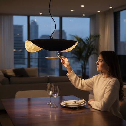 Lysverden LYS Skålpendel in black with gold interior hanging over a dining table in a modern apartment setting