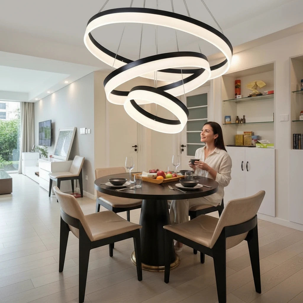Lysverden minimalistisk sort LED-ringpendel hengende over et moderne spisebord med en kvinne som sitter ved bordet.