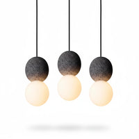 Lysverden Steinpendel trio with grey textured cement spheres and glowing opal glass globes in a Japandi style