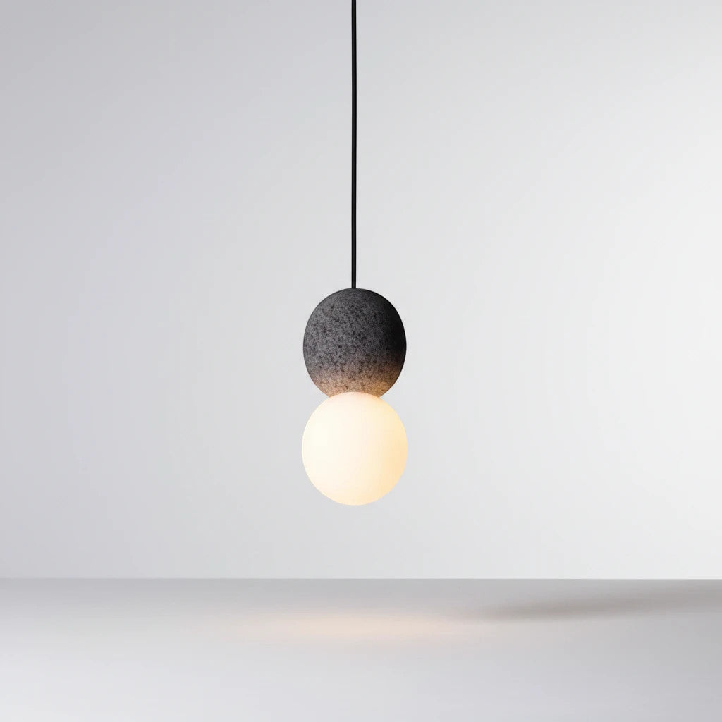 Lysverden Steinpendel pendant light with a grey textured stone sphere and a glowing opal glass globe in Japandi style.