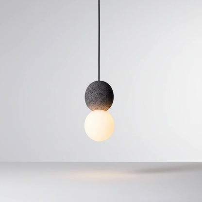 Lysverden Steinpendel pendant light with a grey textured stone sphere and a glowing opal glass globe in Japandi style.