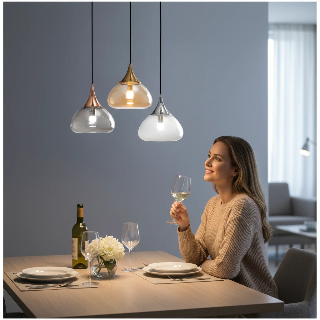 Lysverden glass pendant lights with teardrop clear glass shades and gold, rose gold, and silver metal tops over table