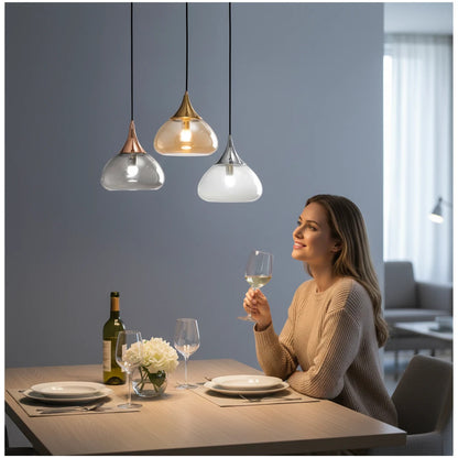 Lysverden glass pendant lights with teardrop clear glass shades and gold, rose gold, and silver metal tops over table