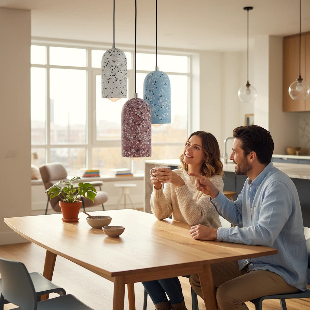 Lysverden TERRAZZO pendant lamps in white, blue, and red concrete hanging over a wooden dining table with a couple.