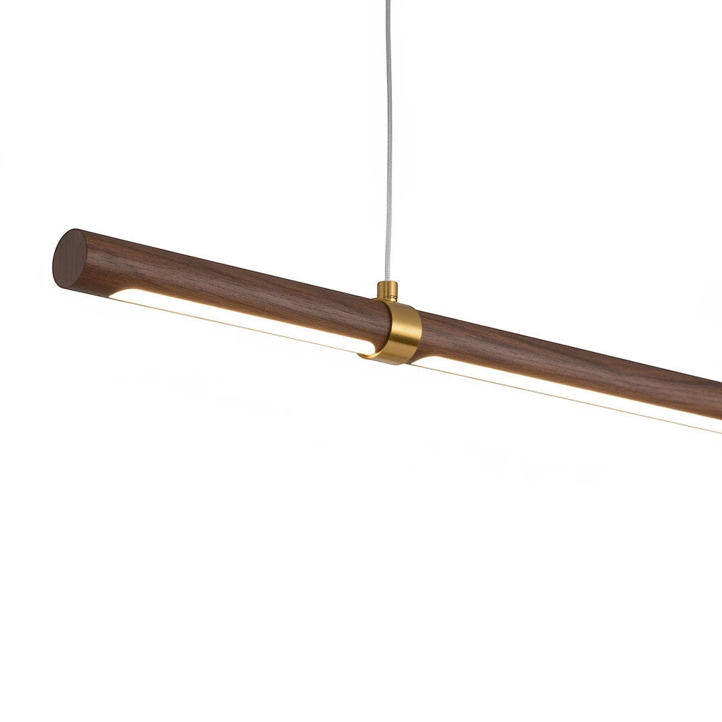 Lysverden linear LED pendant light in walnut wood with a brass accent, providing warm, minimalist Japandi lighting.