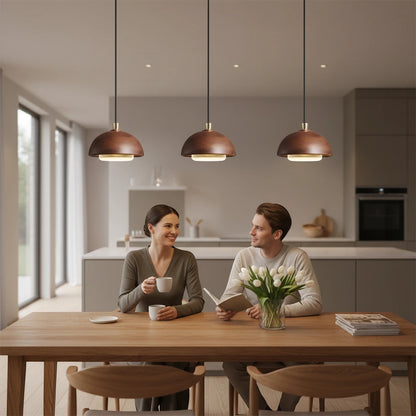 Lysverden walnut wood dome pendant lights hanging over a dining table with a couple sitting in a modern kitchen