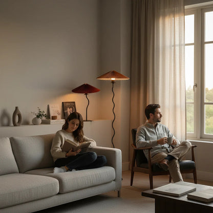 Lysverden sculptural floor lamps with wavy stems and red pleated disk shades in a cozy modern living room setting.