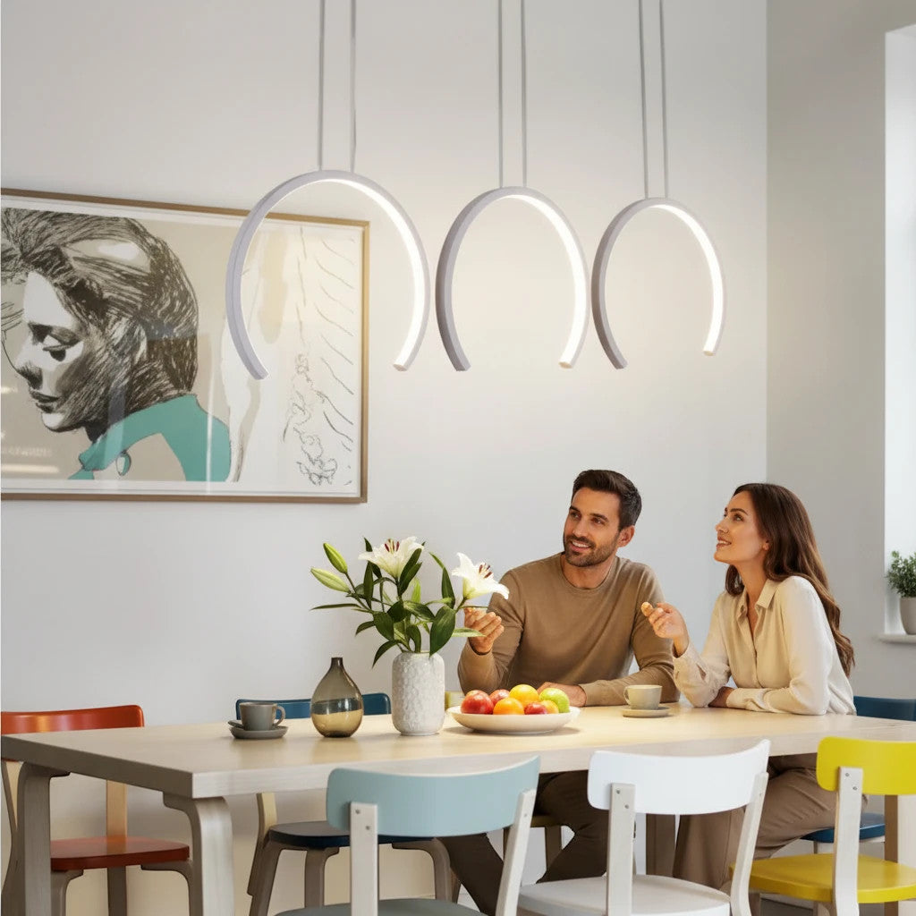 Lysverden modern white curved LED pendant lights hanging above a dining table with a couple sitting in a bright room.
